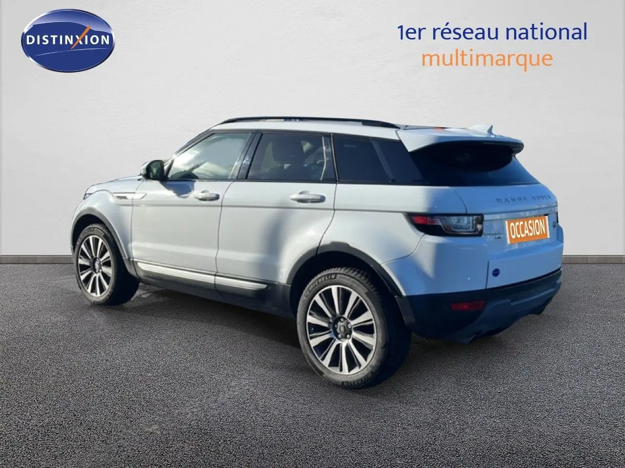 Vue 3/4 arrière gauche d'un Range Rover Evoque blanc 2017 avec jantes alliage bicolores et toit noir contrasté.