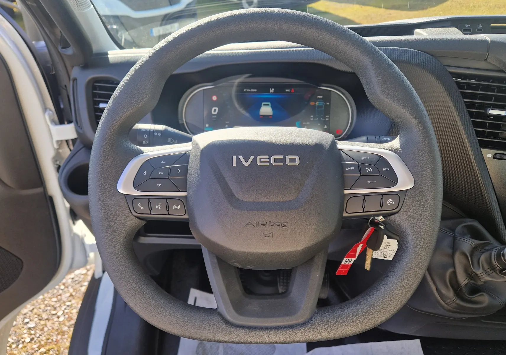 Vue intérieure centrée sur le volant Iveco noir du Daily Chassis Cabine 2026 avec tableau de bord digital en arrière-plan.