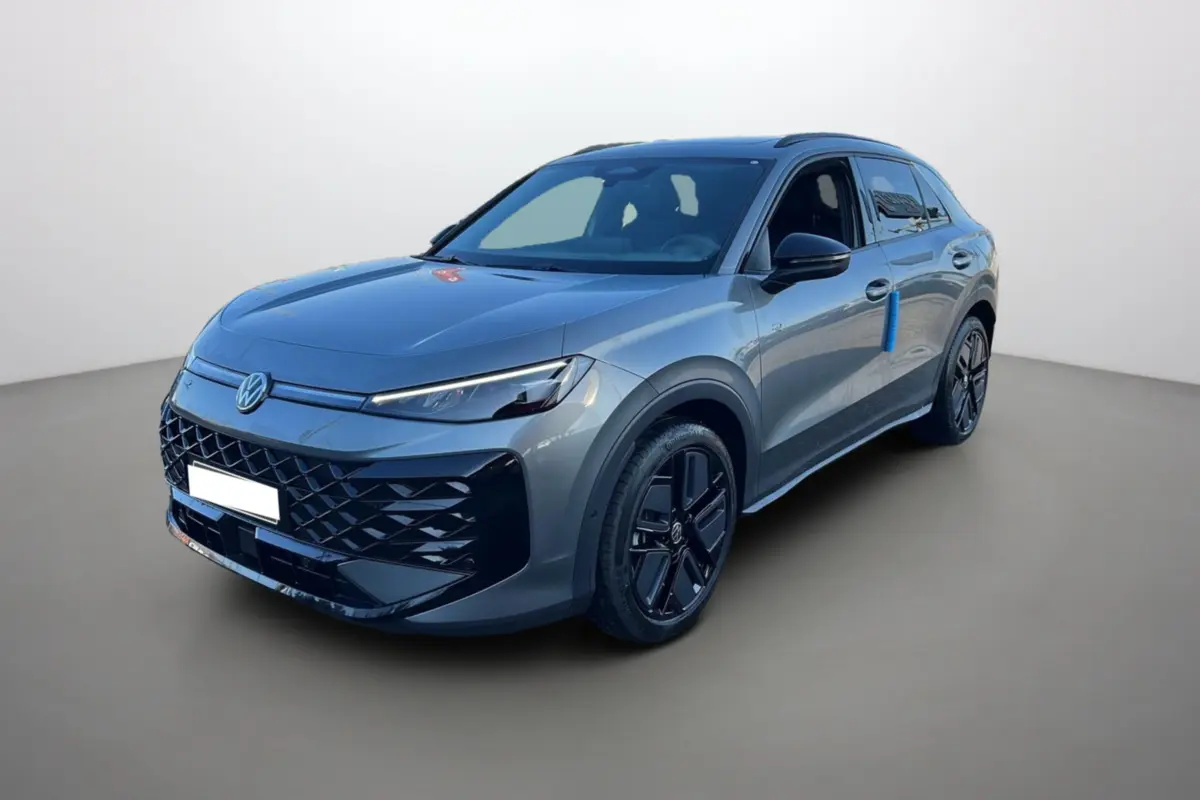 Volkswagen T-Roc gris loup en 3/4 avant droit, avec jantes noires et toit ouvrant panoramique visible.