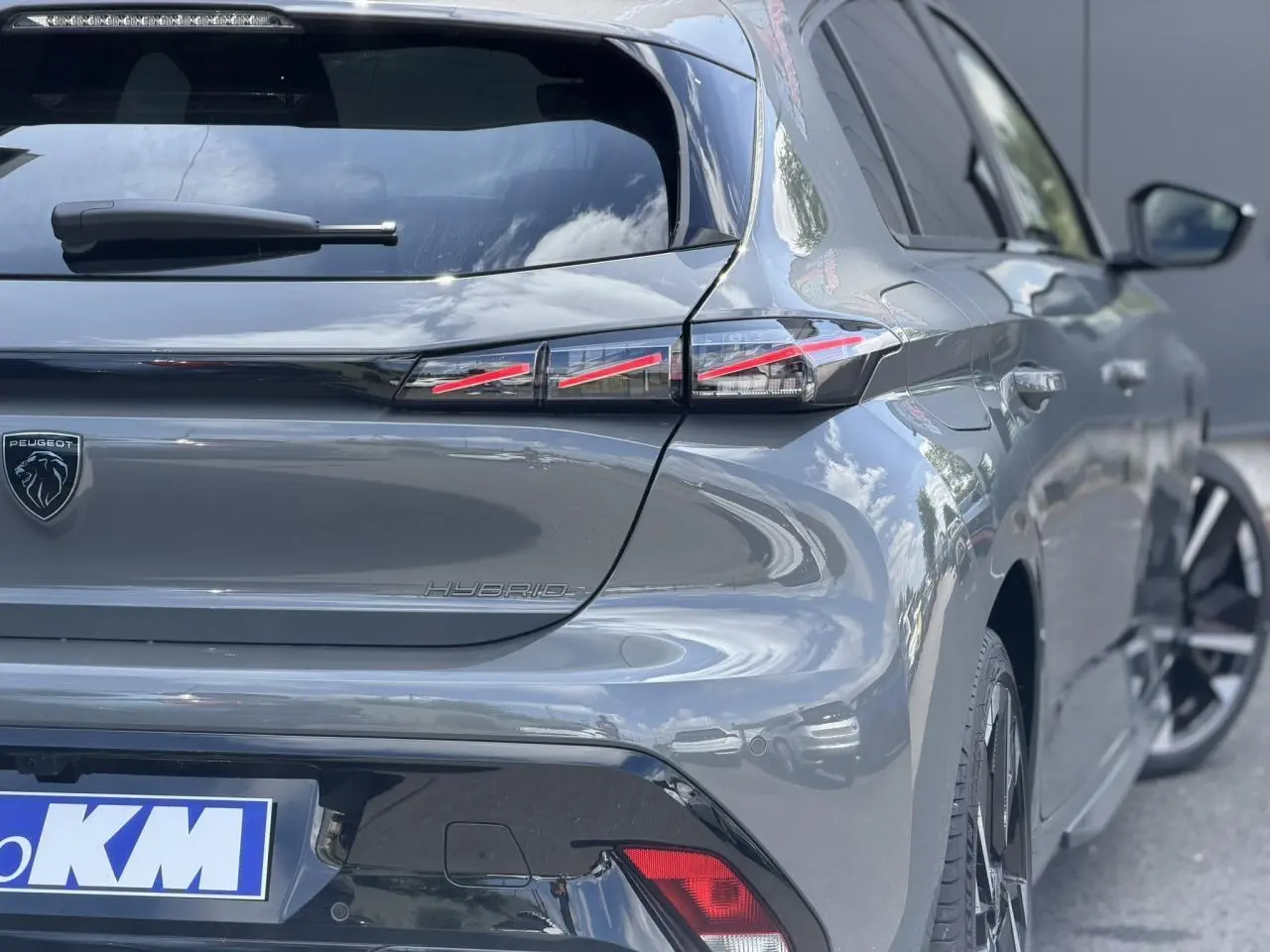 Vue 3/4 arrière droite d’une Peugeot 308 gris Selenium avec feux arrière LED en forme de griffes et jantes alliage bi-tons.
