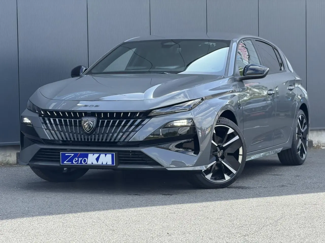 Peugeot 308 gris Selenium vue 3/4 avant avec calandre distinctive et jantes alliage bi-tons.