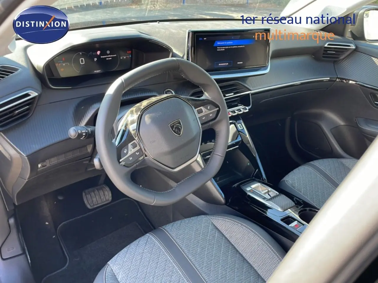Vue intérieure de la Peugeot 208 Hybrid 110ch Allure 2026, tableau de bord moderne et volant compact noir.