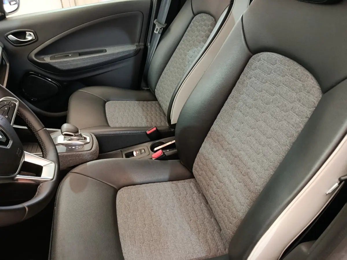 Vue intérieure côté conducteur de la Renault ZOE Intens R110 avec sièges bi-matière gris et noir et volant multifonctions.
