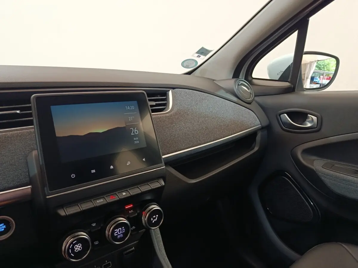 Intérieur de la Renault ZOE Intens blanc, vue côté passager sur tableau de bord avec écran tactile central.