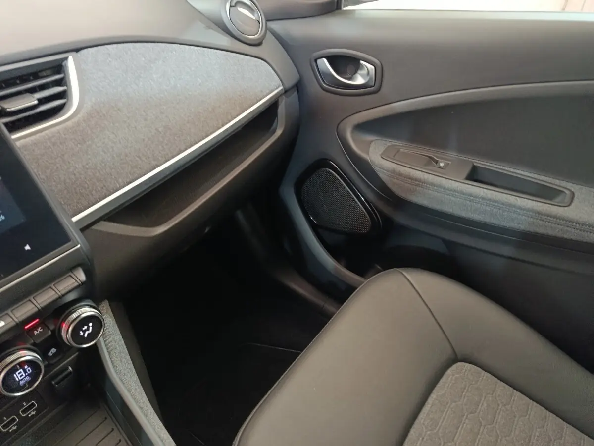 Vue intérieure côté passager de la Renault ZOE Intens R110 2021, avec sellerie grise et tableau de bord texturé.