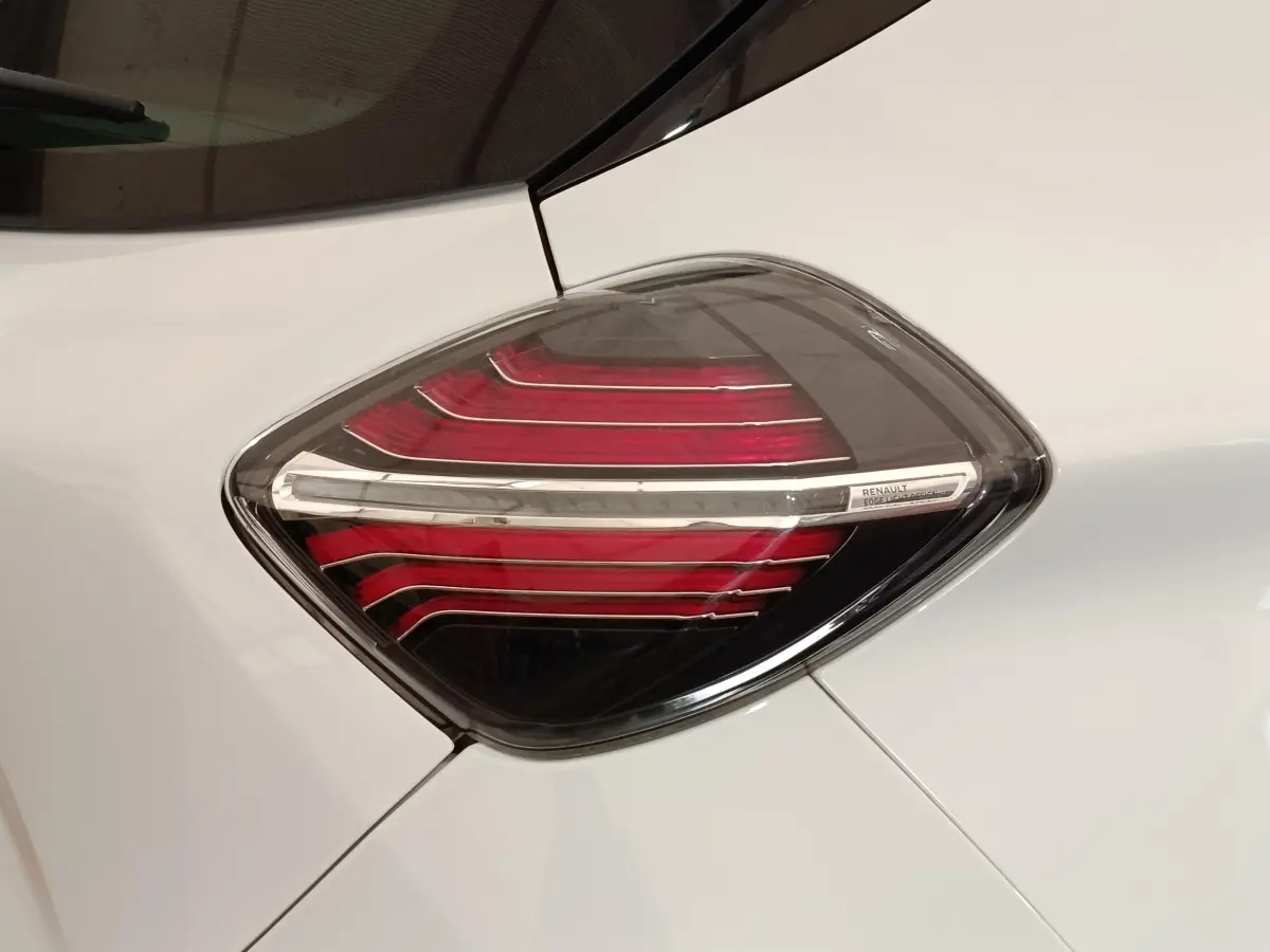 Gros plan sur le feu arrière droit rouge et blanc d’une Renault ZOE Intens R110 blanc nacré.