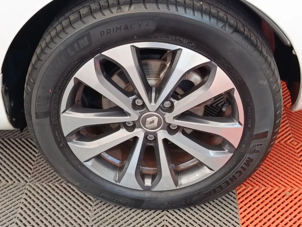 Gros plan sur la roue avant droite d'une Renault ZOE blanche, jante alliage à design moderne et pneu Michelin.