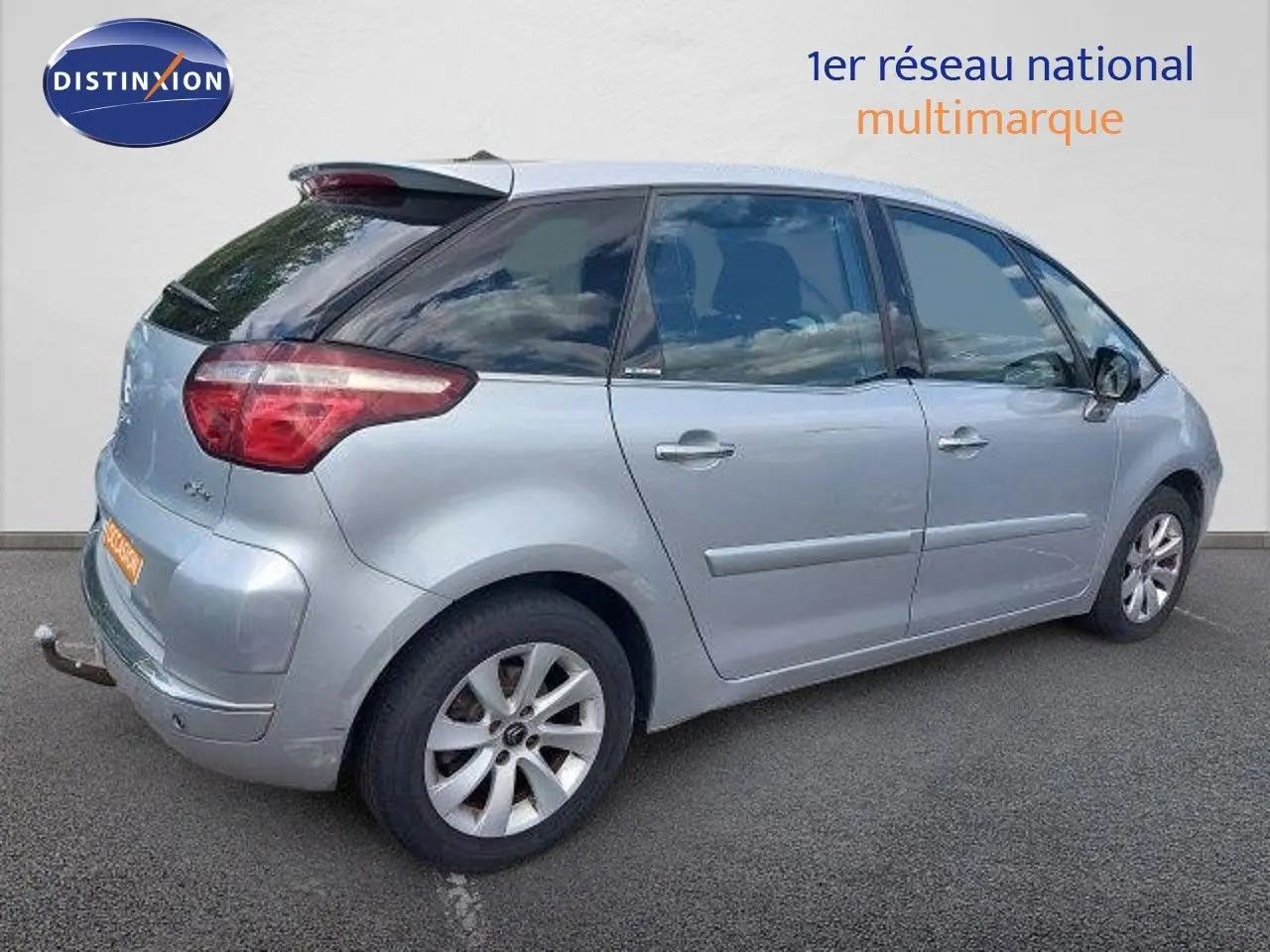 Vue côté droit arrière d'une Citroën C4 Picasso gris alu métal de 2013 avec attelage et jantes alliage.
