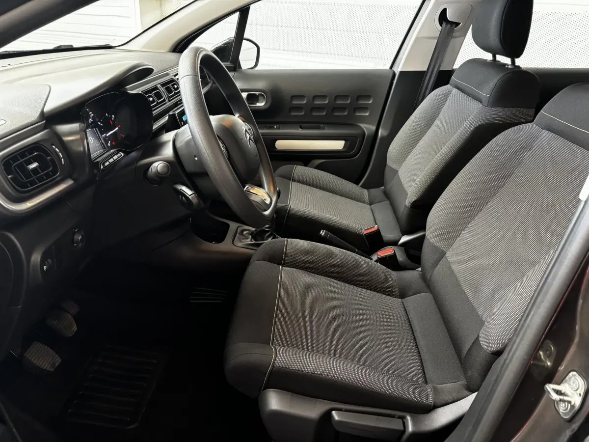 Intérieur avant droit de la Citroën C3 2024 gris foncé, avec sièges tissu et tableau de bord moderne tactile.