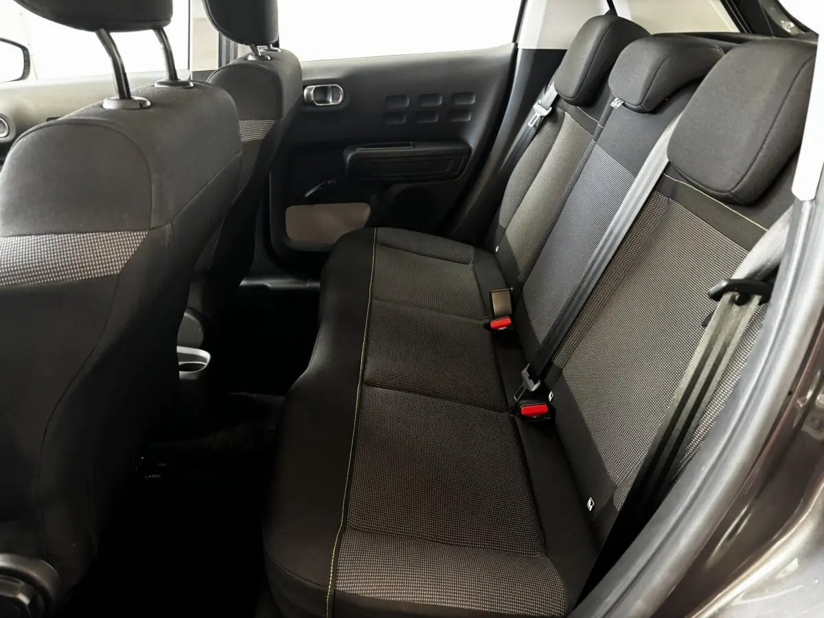Vue intérieure côté droit sur la banquette arrière en tissu gris et noir de la Citroën C3 PureTech 110 2024.