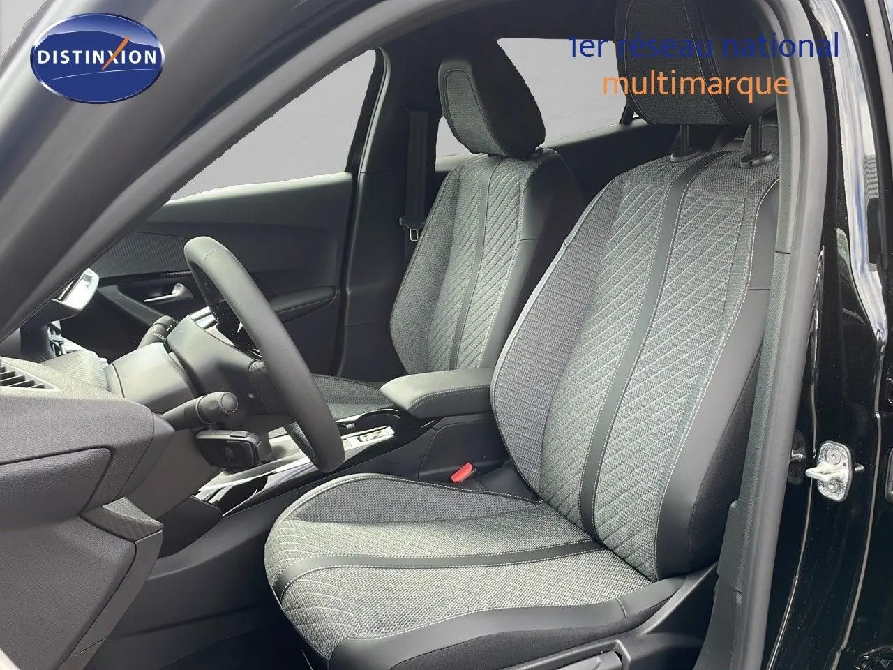 Intérieur de la Peugeot 2008 2025 noir perla metal, vue côté conducteur sur sièges tissu et cuir gris détaillés.