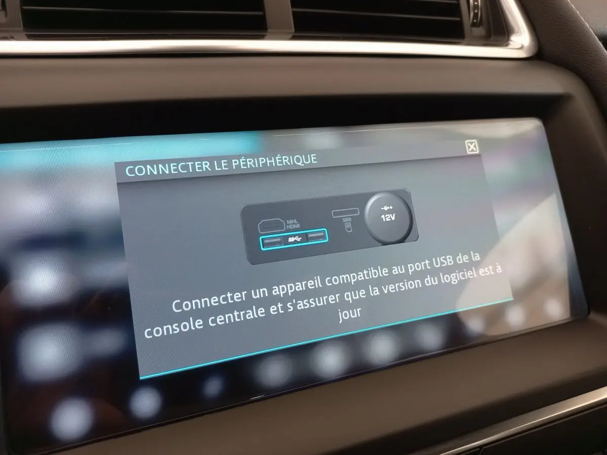 Écran tactile central du tableau de bord du Jaguar E-PACE blanc, affichant une invite de connexion USB.