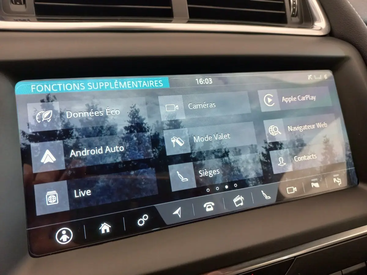 Écran tactile central affichant les fonctions connectées Apple CarPlay et Android Auto dans une Jaguar E-PACE blanche de 2019.