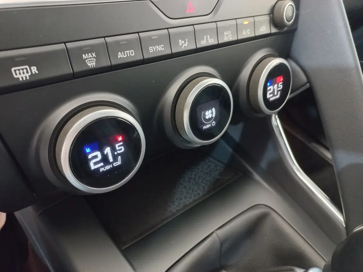 Gros plan sur les commandes de climatisation digitale du tableau de bord du Jaguar E-PACE blanc, version D180 BVM AWD R-DYNAMIC S.
