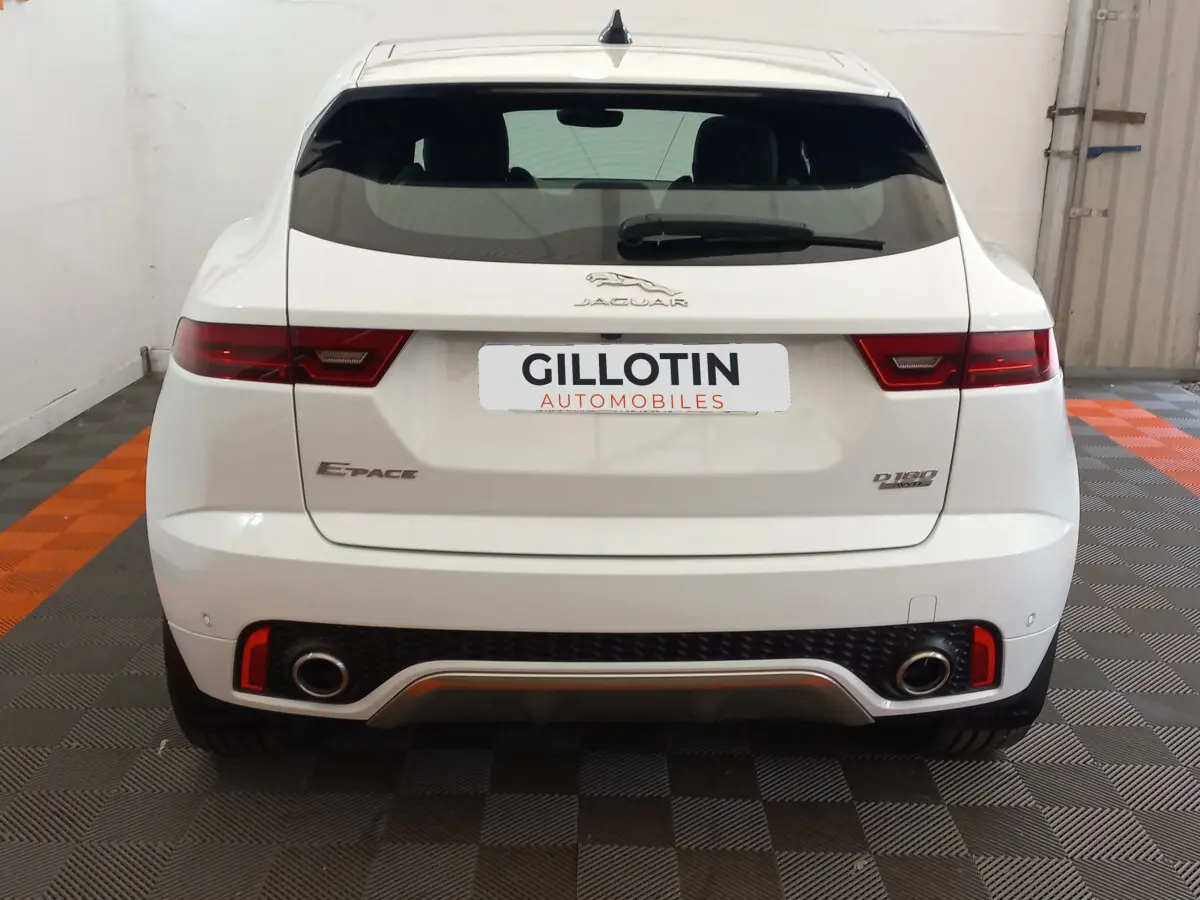 Vue arrière d'un Jaguar E-PACE blanc D180 Diesel avec double sortie d'échappement et feux LED distinctifs.