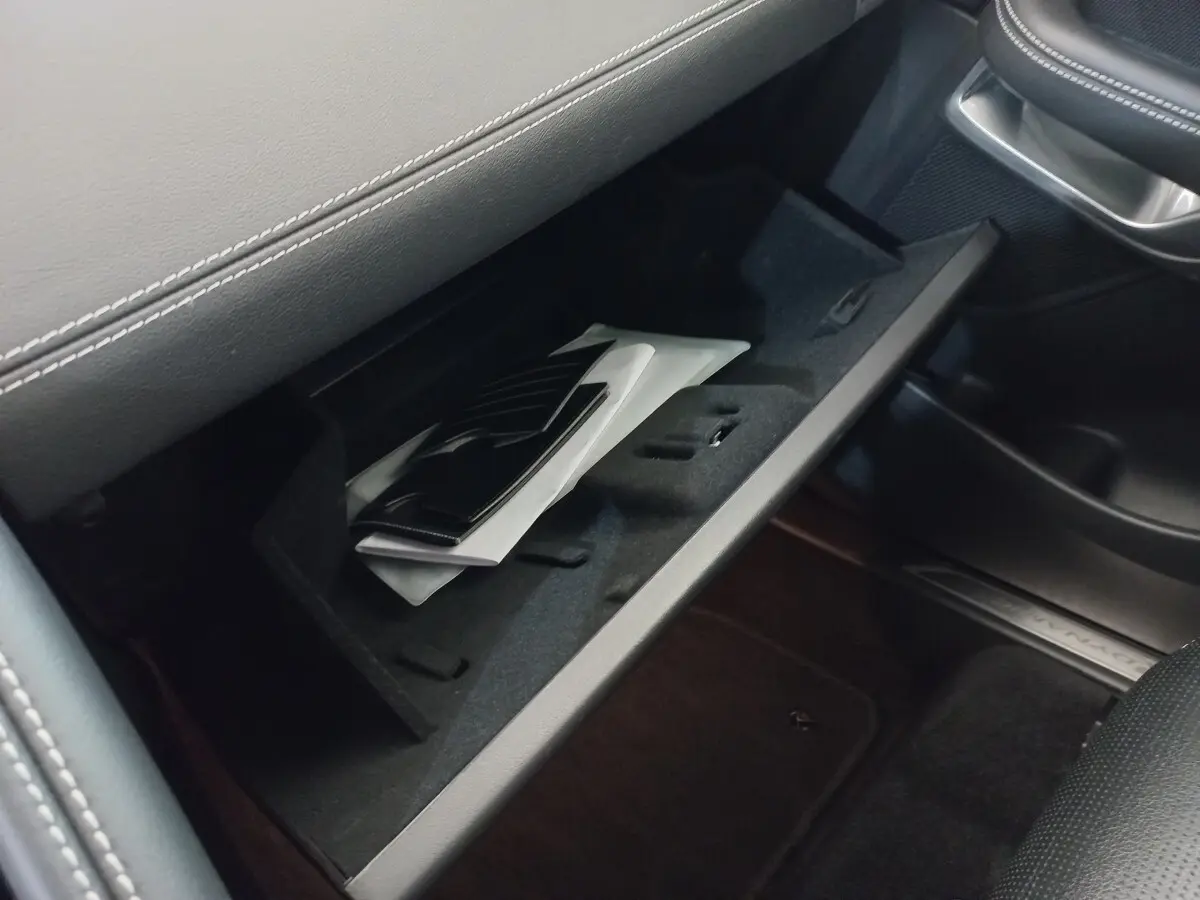 Gant de boîte à gants ouvert côté passager dans Jaguar E-PACE blanc, intérieur noir avec surpiqûres grises.