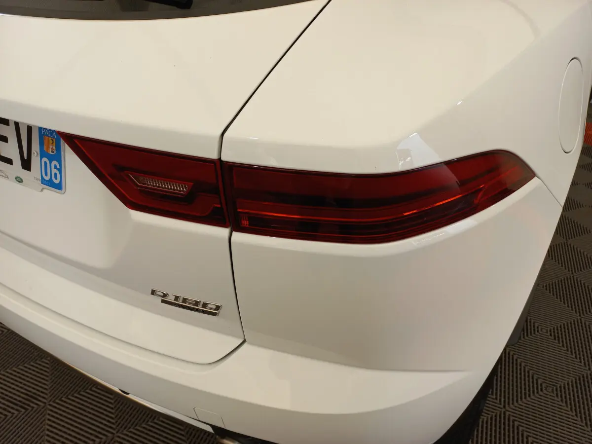 Gros plan sur l'arrière droit blanc du Jaguar E-PACE D180 avec feu arrière rouge et badge diesel visible.