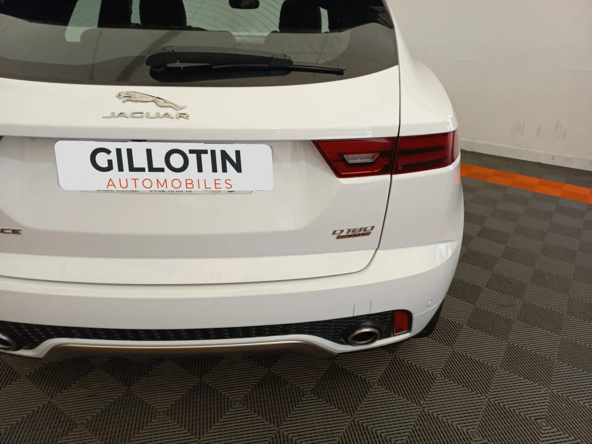 Vue arrière droite d'un Jaguar E-PACE blanc D180 Diesel avec feux LED et double sortie d'échappement visible.