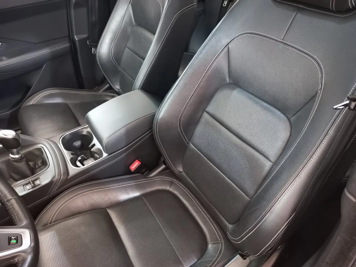 Vue rapprochée des sièges avant en cuir noir et console centrale d'une Jaguar E-PACE blanc 2019.