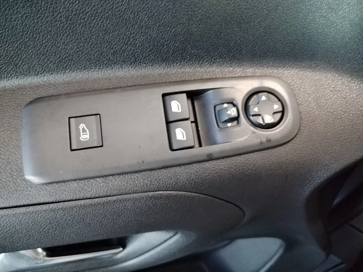 Gros plan sur les commandes de réglage des rétroviseurs et des vitres côté conducteur du Citroën Berlingo gris acier 2025.