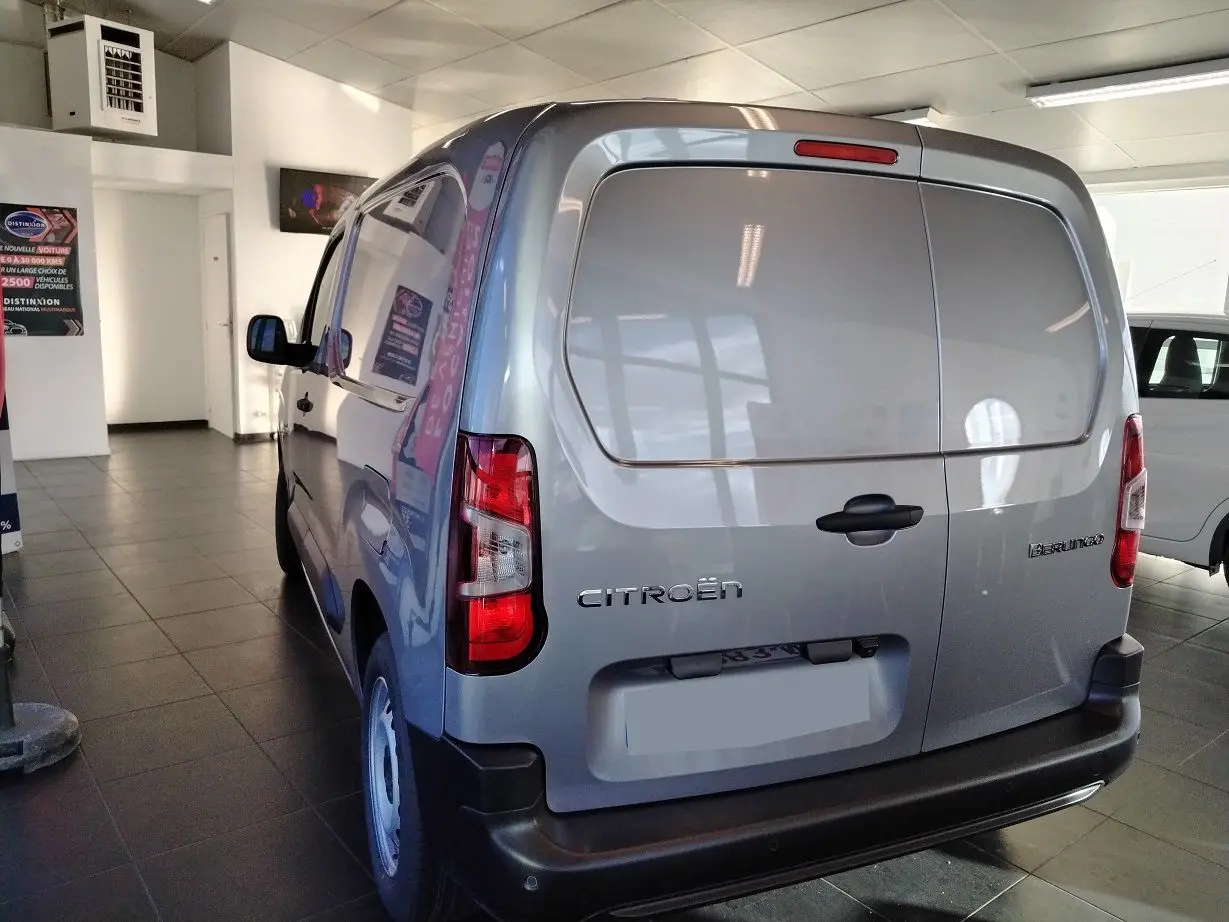 Vue 3/4 arrière droite d'un Citroën Berlingo Van gris acier avec portes arrière pleines dans un showroom.