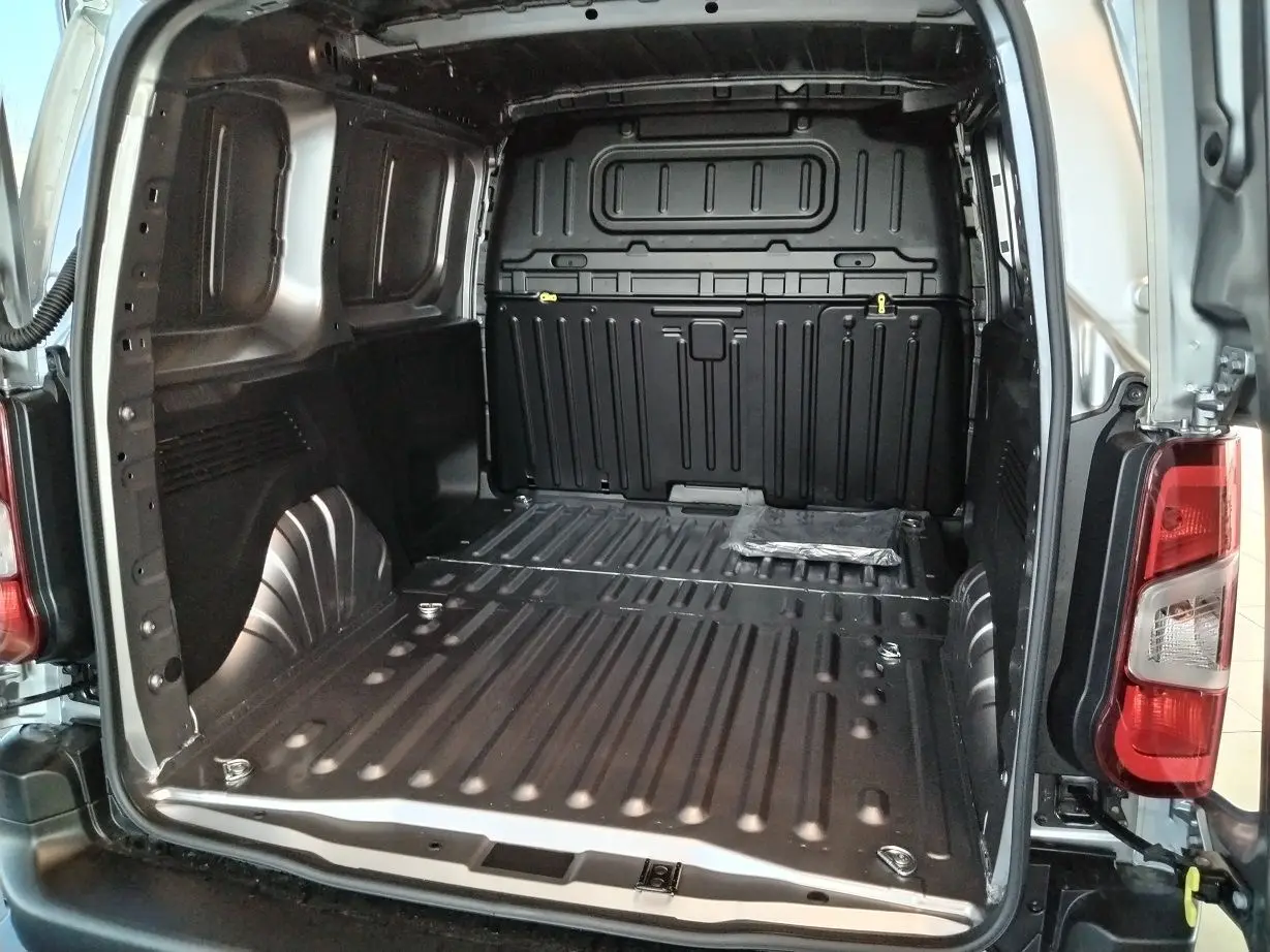 Vue arrière ouverte du Citroën Berlingo Van gris acier 2025 montrant l'espace de chargement métallique vide.