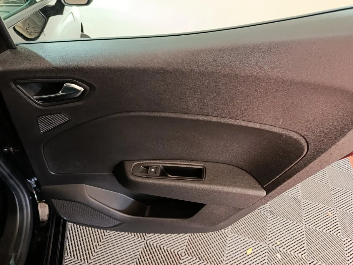 Intérieur côté gauche de la porte avant noire de la Renault Clio Evolution Blue dCi 100 -25, avec poignée et commande de vitre.