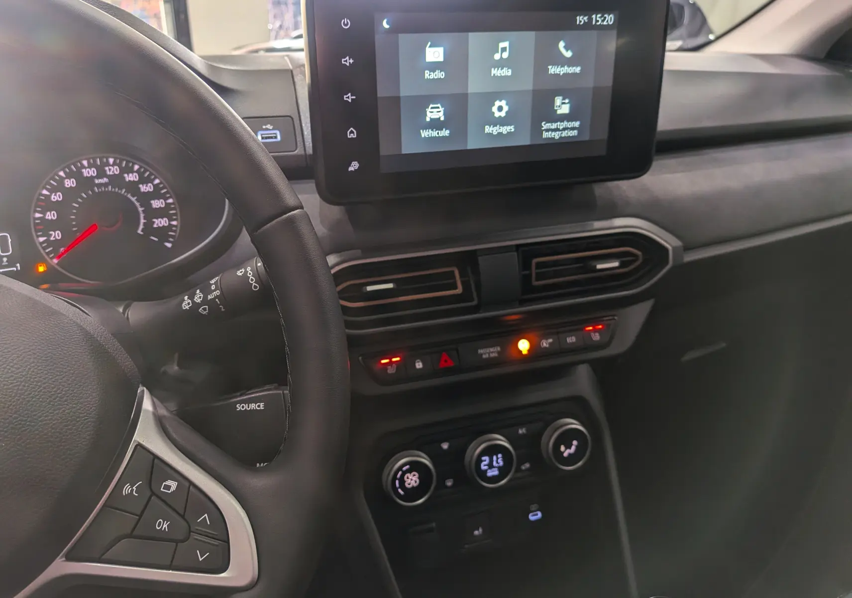 Vue intérieure côté conducteur du tableau de bord de la Dacia Sandero Stepway 2025 avec écran tactile et commandes climatisation.