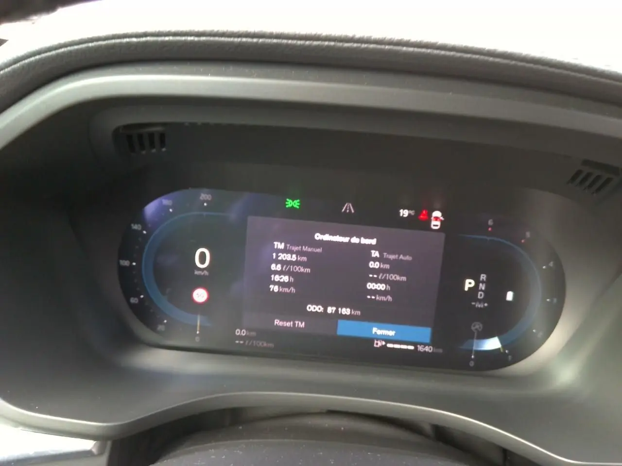 Vue latérale droite d'un Volvo XC60 bleu 2023 avec jantes alliage 20'' noir et diamant dans un garage.