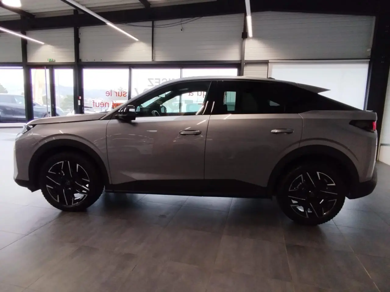 Vue latérale droite du Peugeot 3008 2024 gris Artense avec jantes alliage noires et détails noirs contrastés.