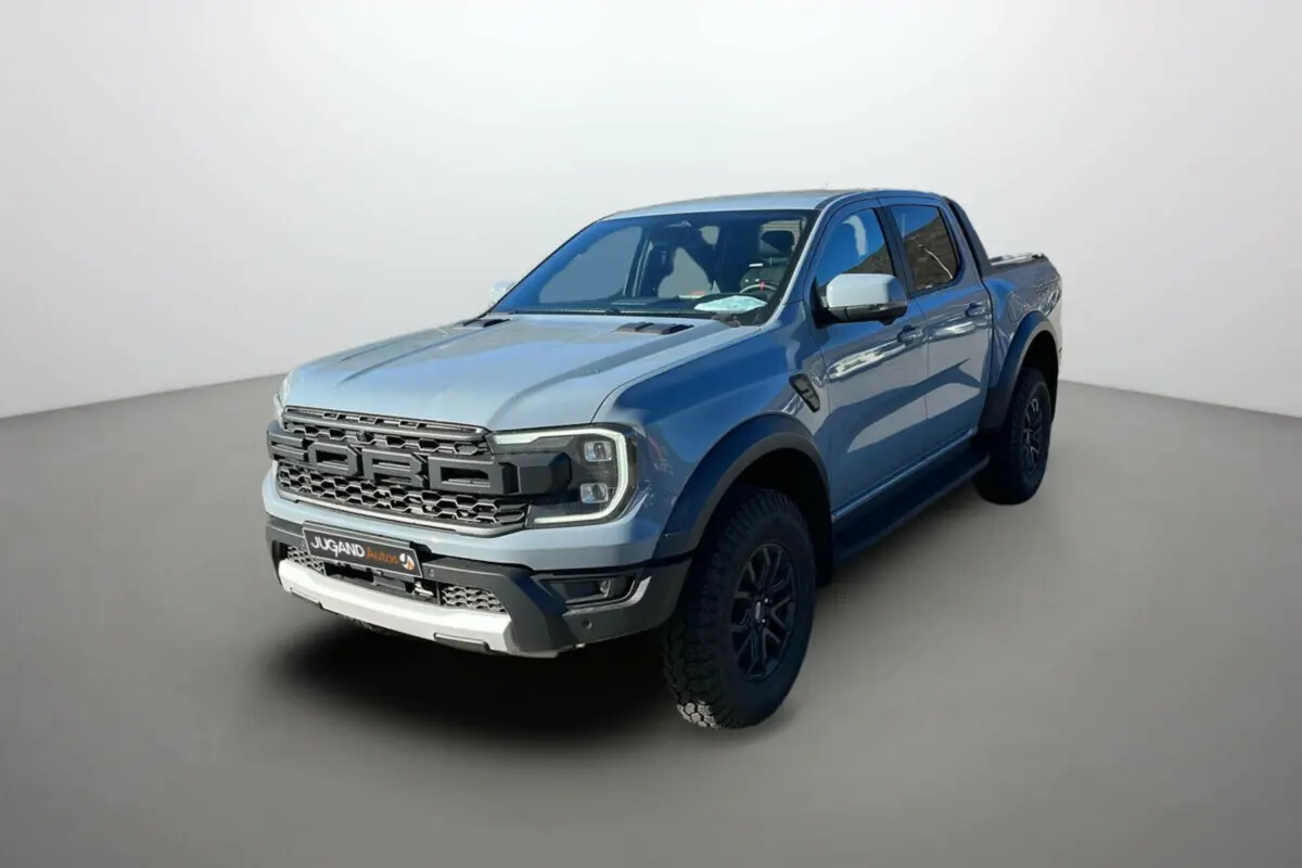 Ford Ranger Raptor gris commandeur vu en 3/4 avant droit avec calandre imposante et jantes noires.