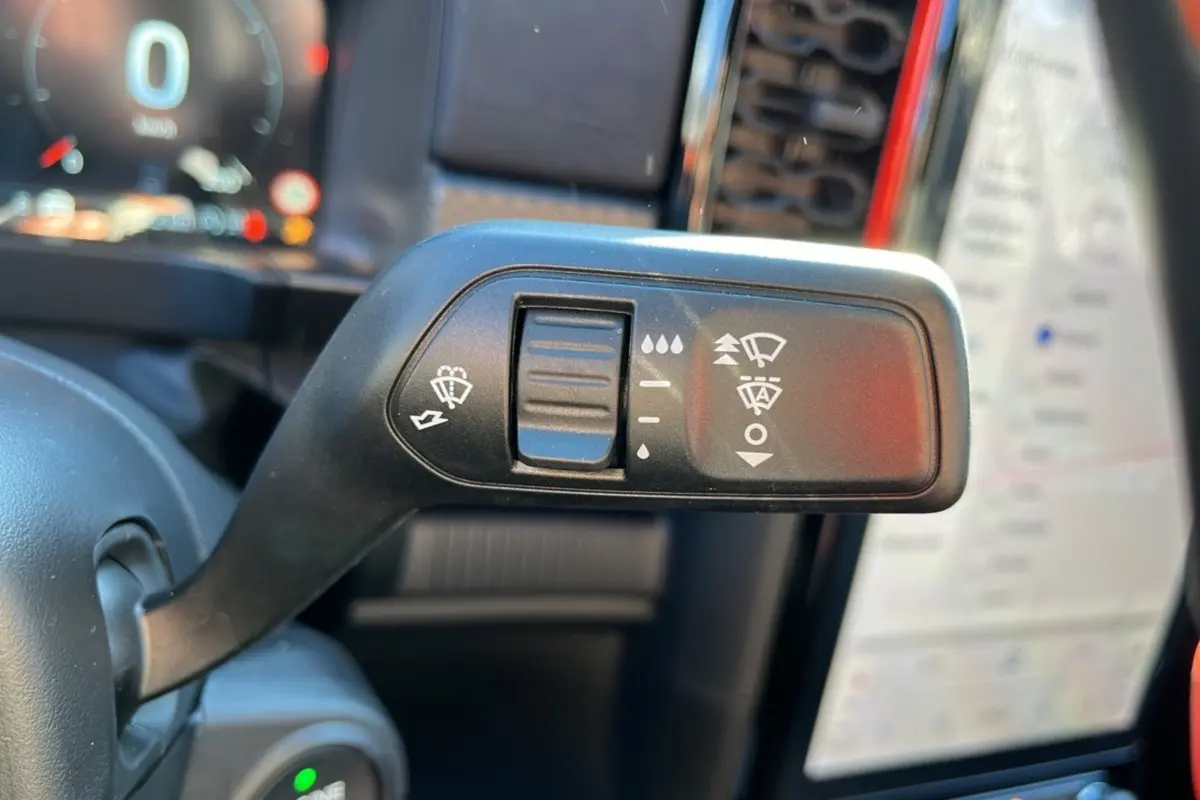 Gros plan sur la commande des essuie-glaces du Ford Ranger Raptor 2026, intérieur avec écran tactile en arrière-plan flou.