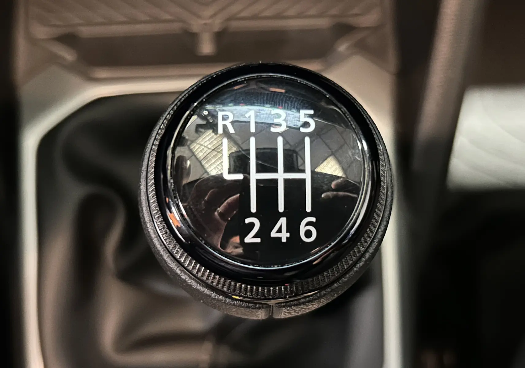Gros plan sur le pommeau de la boîte manuelle du Dacia Duster 2024, avec marquage des six vitesses et marche arrière.