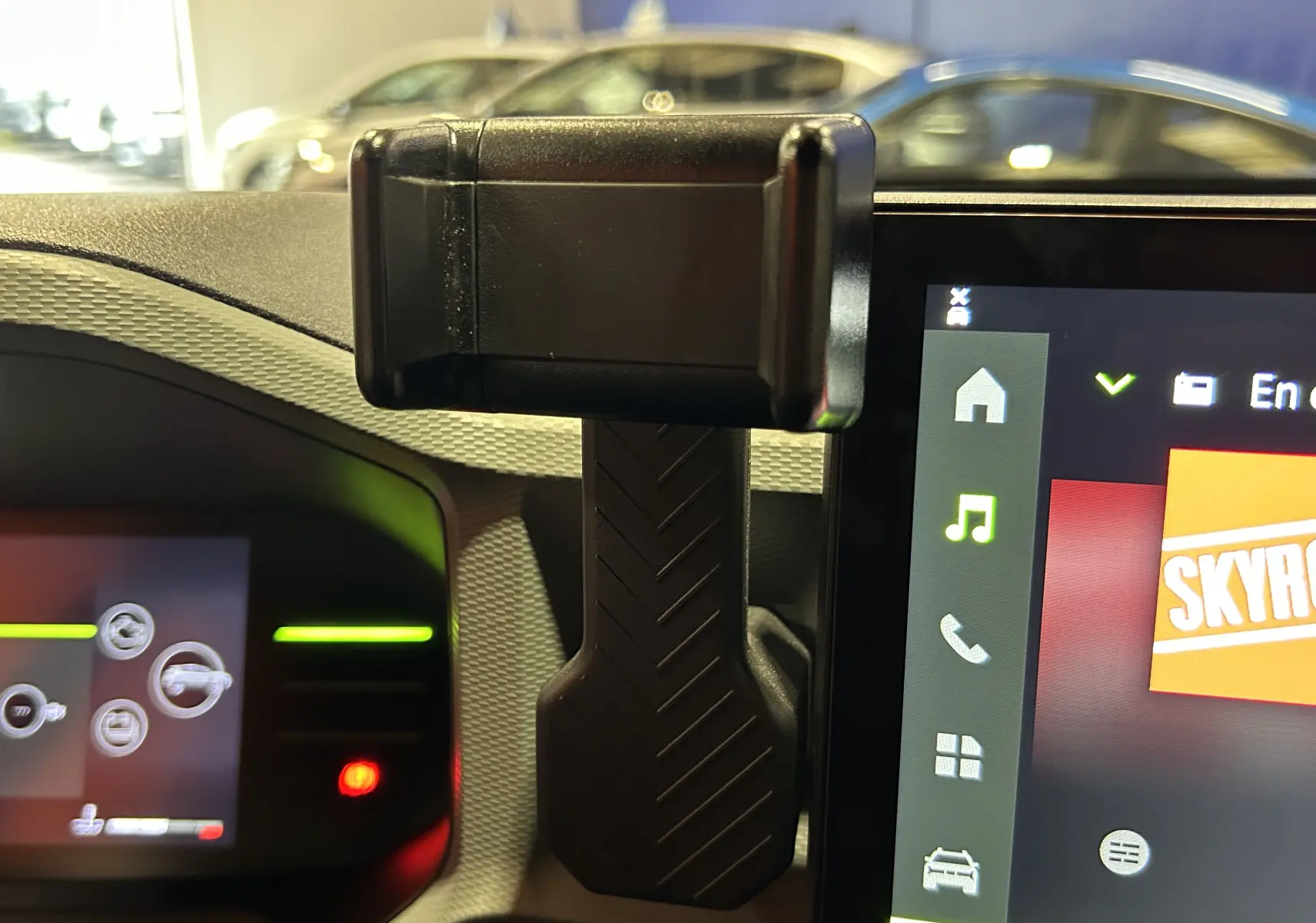 Vue intérieure du tableau de bord du Dacia Duster 2024 avec support téléphone et écran tactile multimédia allumé.