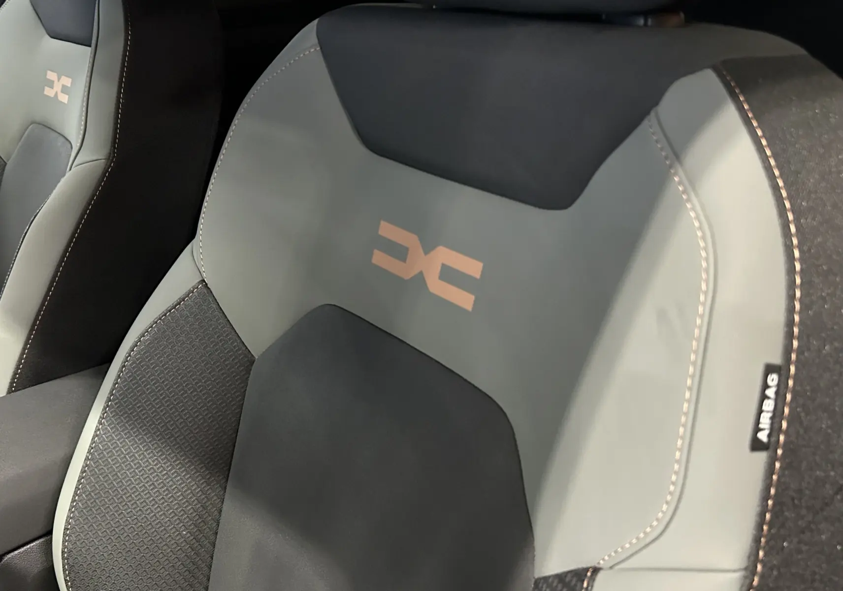 Gros plan sur le siège avant du Dacia Duster 2024 TCE 130 4x4 Extreme en tissu noir et gris avec logo DC brodé.