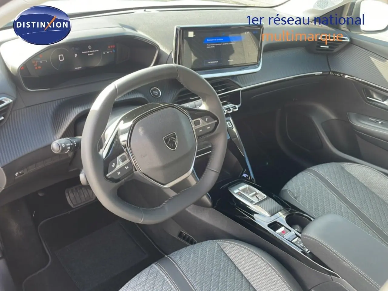 Vue intérieure avant droite du Peugeot 208 Hybrid blanc, avec volant compact et écran tactile central lumineux.