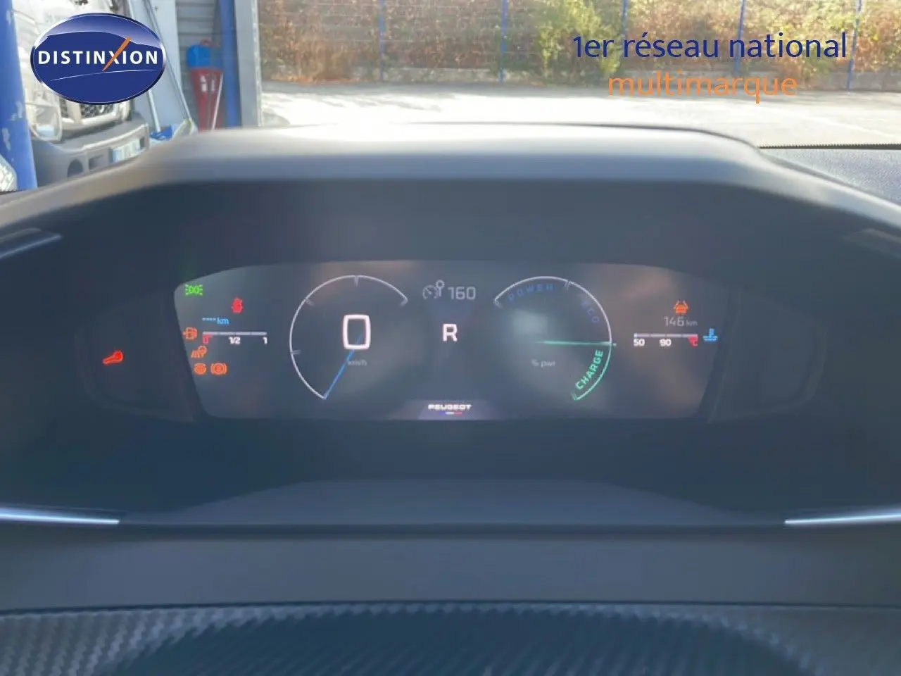 Vue du tableau de bord numérique de la Peugeot 208 Hybrid blanc Okenite, affichant la vitesse et l'autonomie.