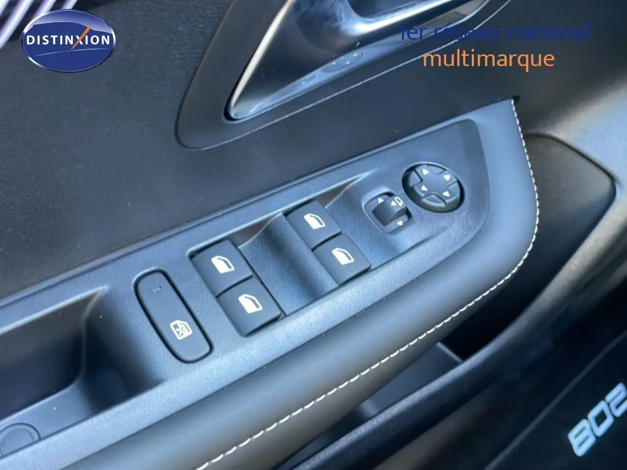Gros plan sur la commande des vitres électriques côté conducteur de la Peugeot 208 Hybrid blanche, avec surpiqûres blanches.
