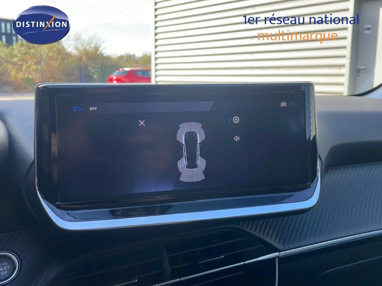 Écran tactile central affichant l’aide au stationnement dans l’habitacle d’une Peugeot 208 blanche, vue de face.