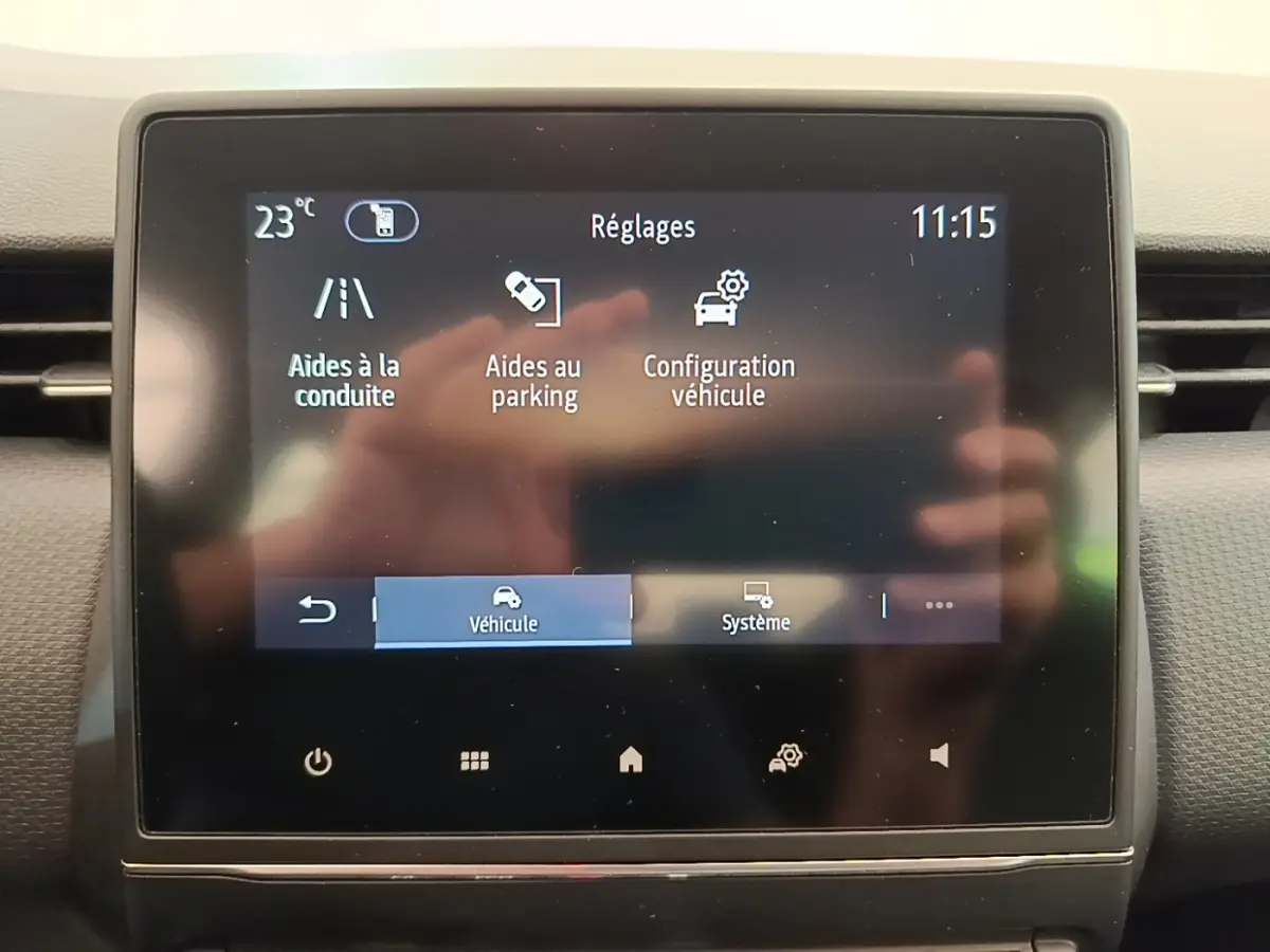 Écran tactile central de la Renault Clio Business E-TECH 140 blanc, affichant les réglages d’aides à la conduite.