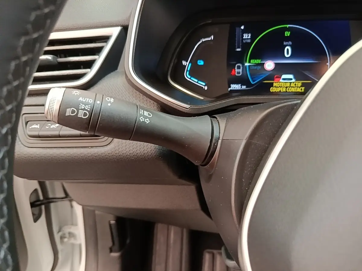 Vue rapprochée du combiné d'instruments et du commodo gauche de la Renault Clio Business E-TECH 140 blanche, affichage numérique.