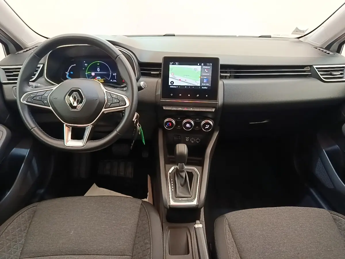 Vue intérieure avant centrée sur le tableau de bord et volant cuir noir de la Renault Clio Business E-TECH 140 hybride.