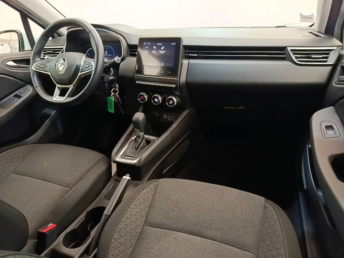 Vue intérieure avant de la Renault Clio Business E-TECH 140, tableau de bord noir avec écran tactile central et volant multifonctions.