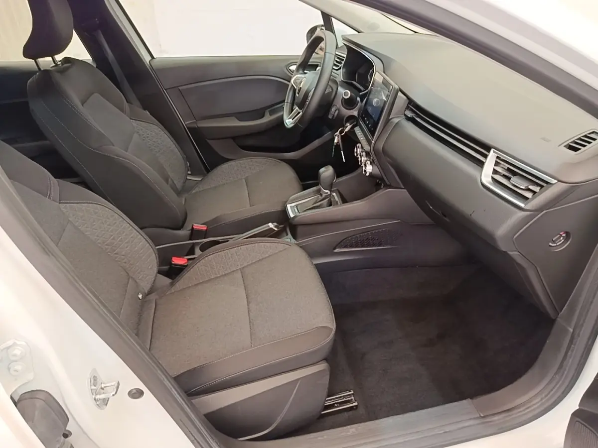Intérieur de la Renault Clio Business E-TECH 140 blanc, vue côté conducteur montrant sièges et tableau de bord moderne.
