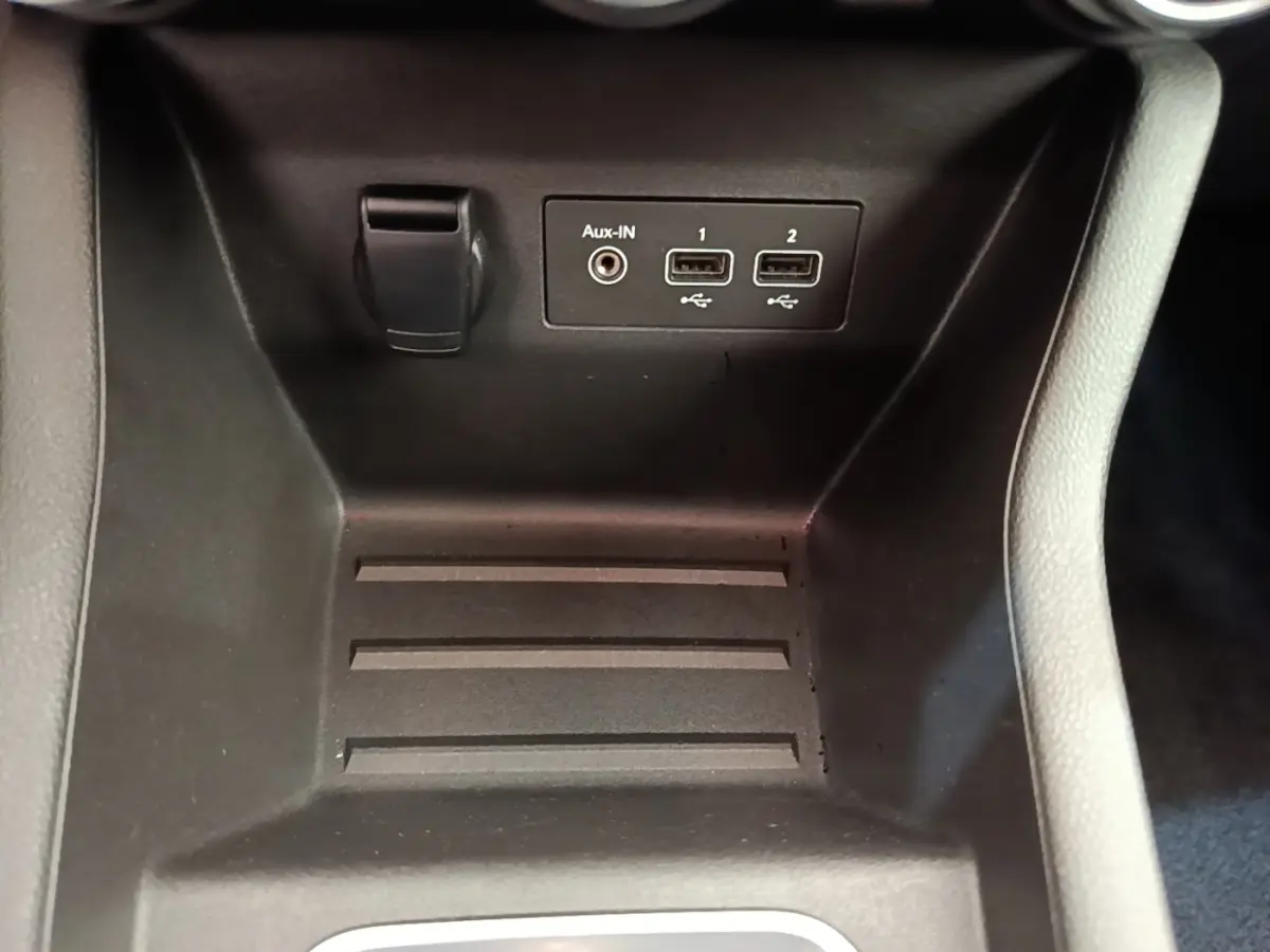 Gros plan sur la console centrale de la Renault Clio Business E-TECH 140, montrant ports USB et prise Aux-In.