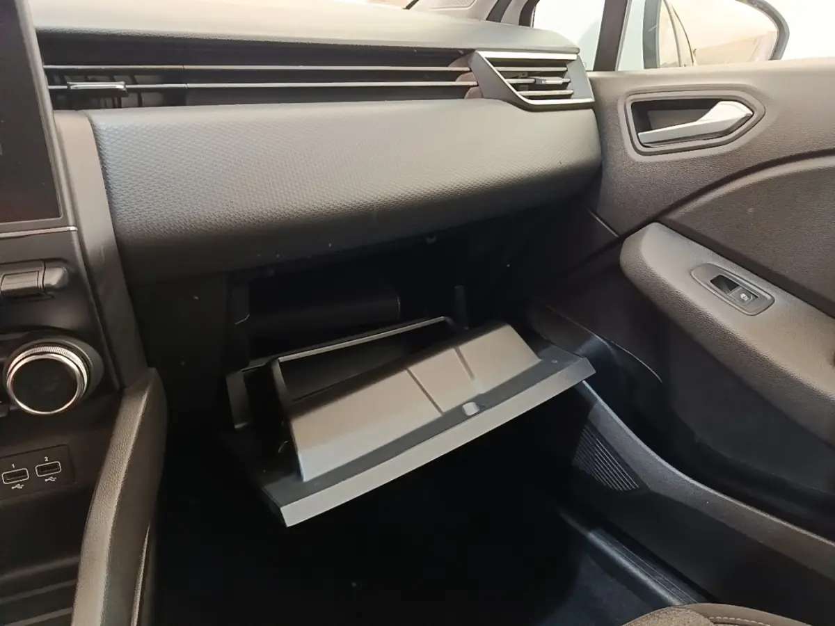 Intérieur de la Renault Clio Business E-TECH 140 2021, vue côté passager sur la boîte à gants ouverte et tableau de bord noir.