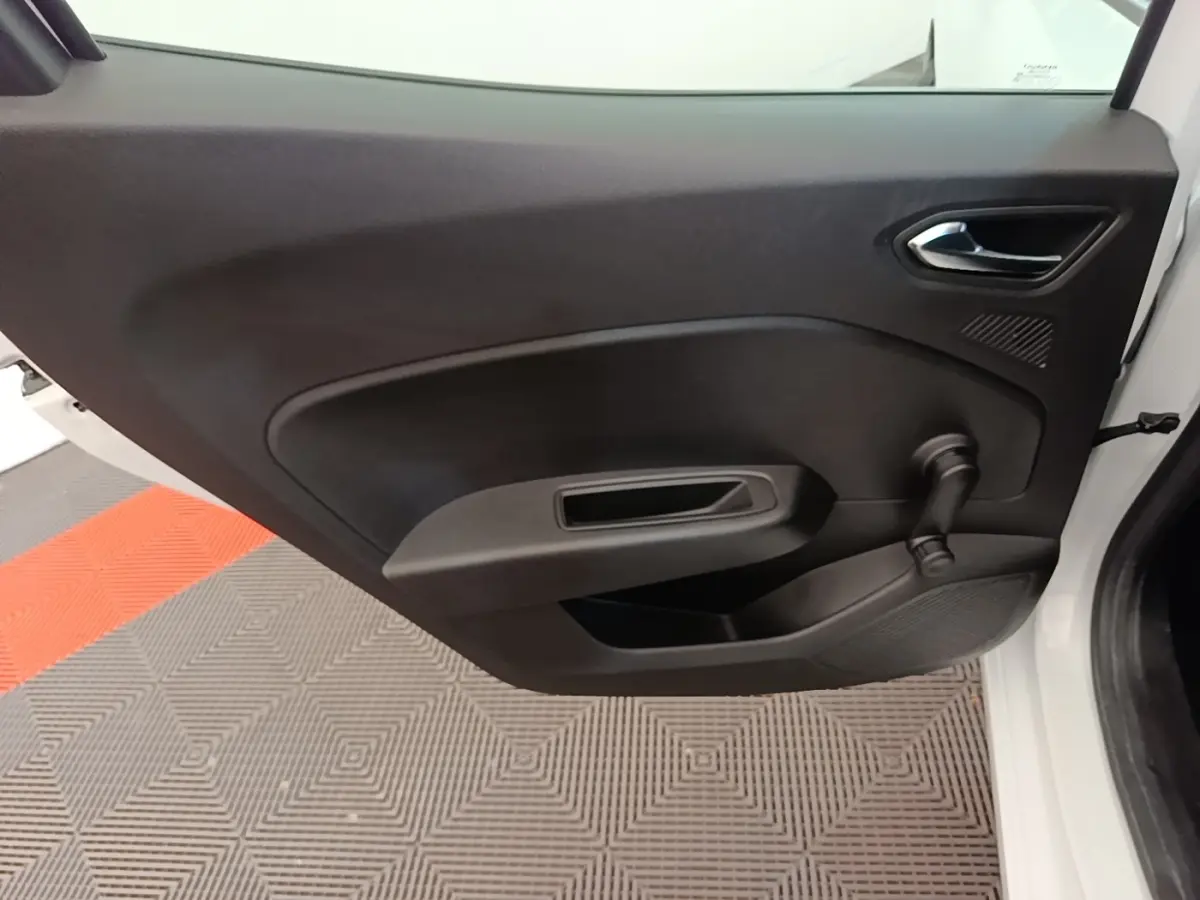 Vue intérieure de la porte avant droite d'une Renault Clio blanche, avec poignée et manivelle de vitre noire.
