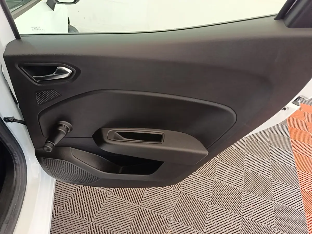 Vue intérieure de la porte arrière gauche blanche de la Renault Clio Business E-TECH 140 avec poignée manuelle de vitre.