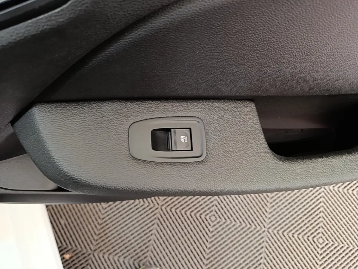Bouton de verrouillage centralisé sur la porte intérieure côté conducteur d'une Renault Clio Business E-TECH blanche.