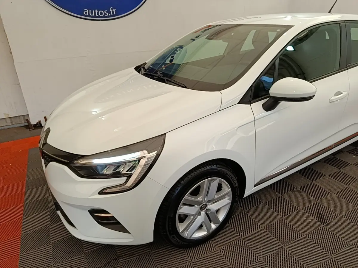 Vue 3/4 avant droite d'une Renault Clio Business E-TECH blanche avec phares LED et jantes alliage.